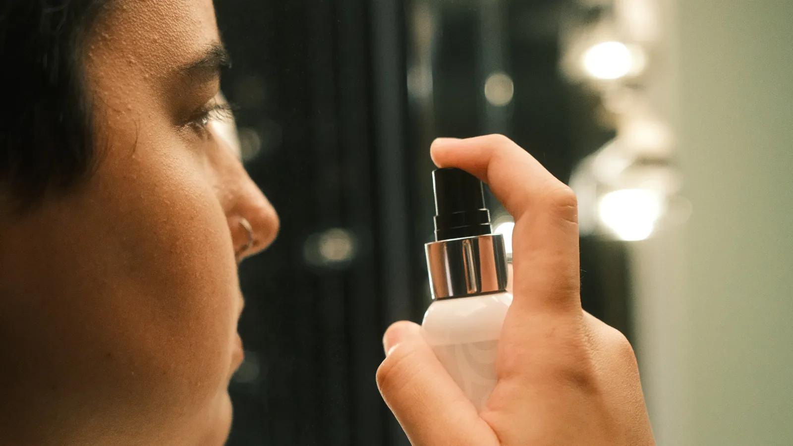 Persona con piercing en la nariz aplicándose el Piercing Aftercare Spray