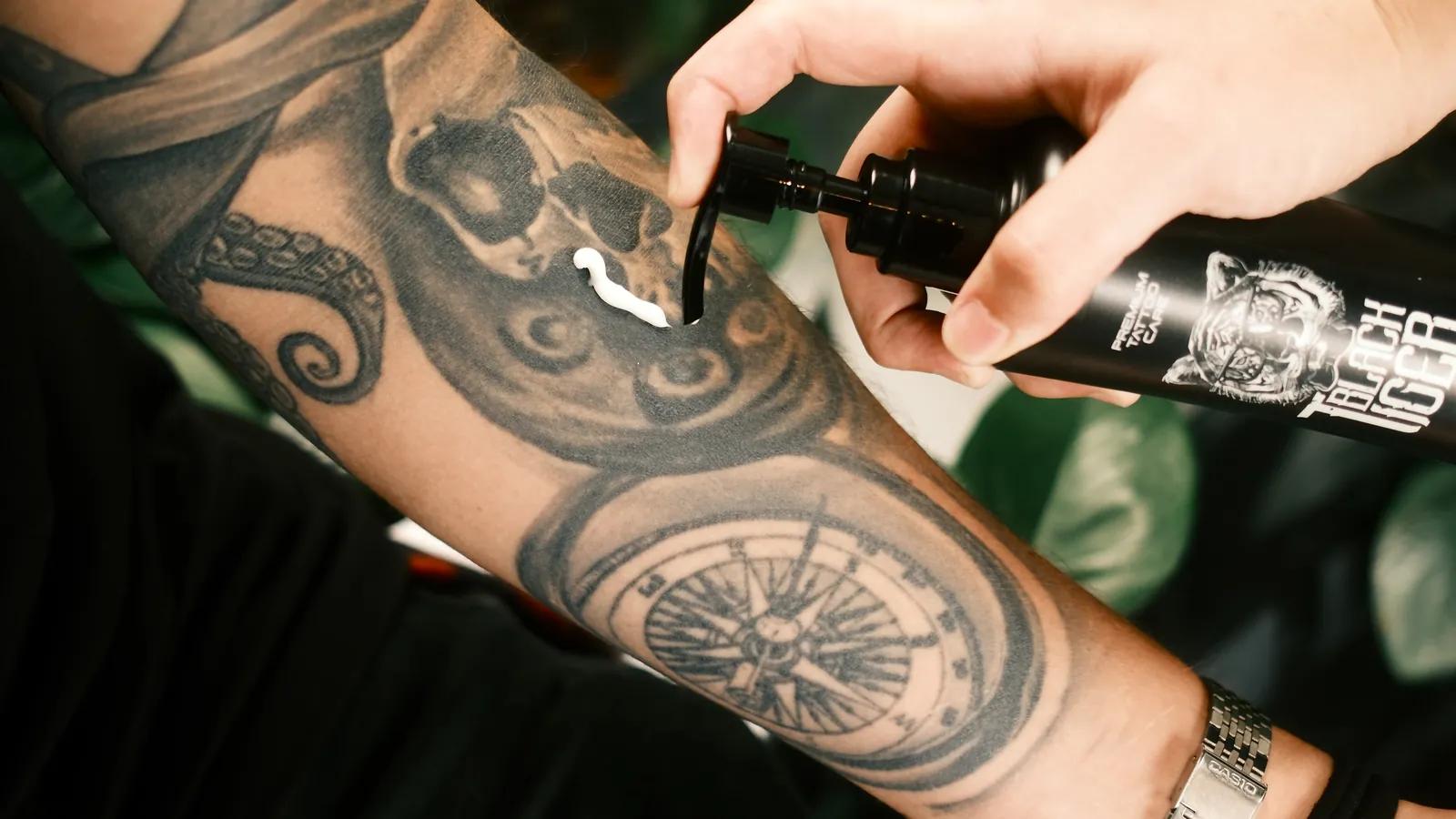 Crema hidratante Black Tiger aplicada sobre un brazo tatuado